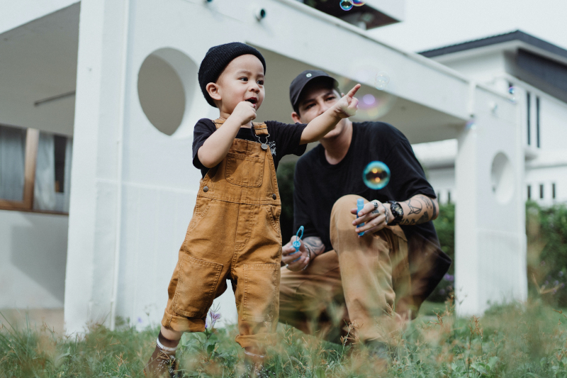 Man With a Boy On Lawn In Front of a House - From Pexels
