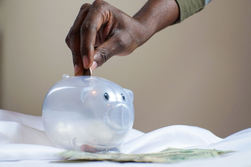 Person Putting Coin in a Piggy Bank - From Pexels